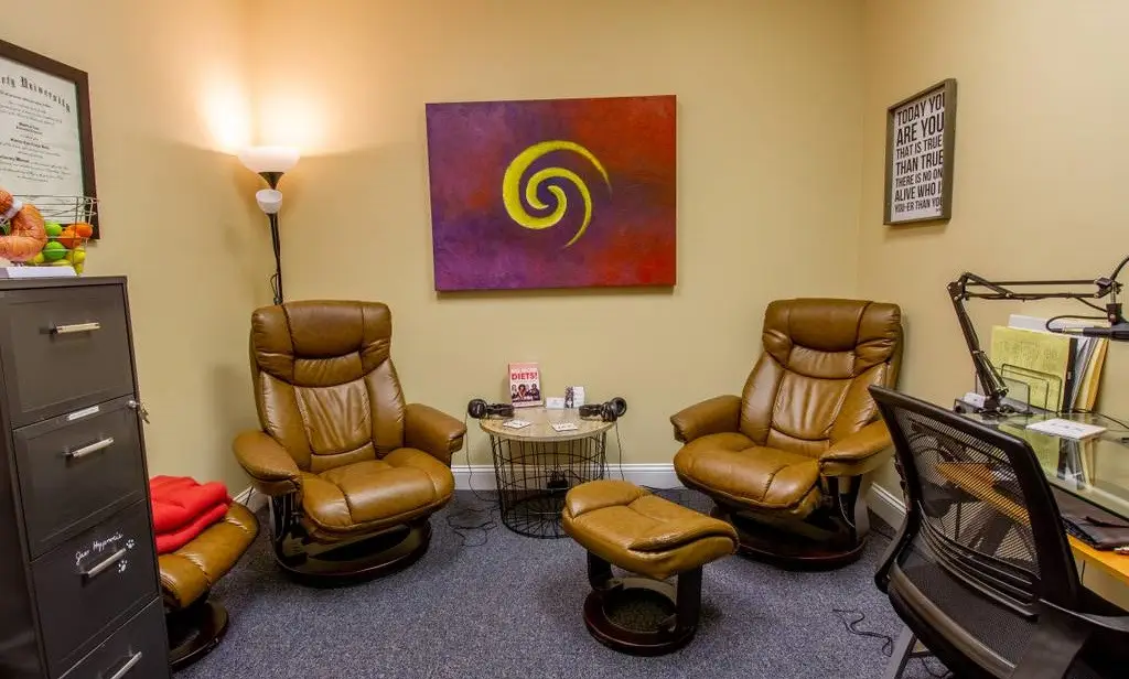 Private JAX Hypnosis session room in Jacksonville with two leather recliners and a footrest