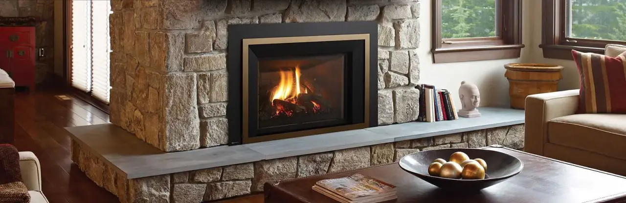 Regency fireplace insert burning in a stone living room hearth.