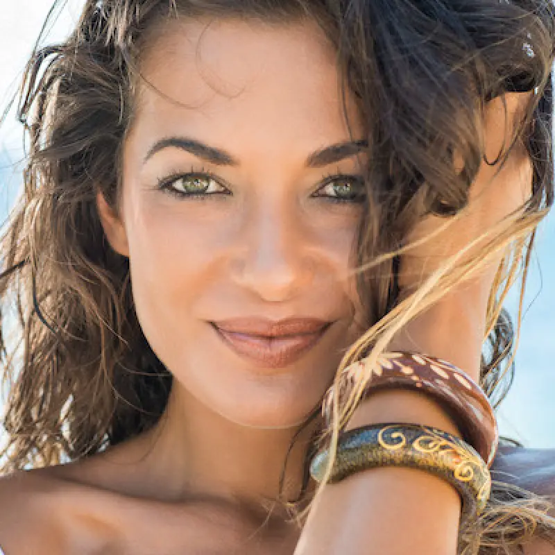 beautiful woman with two wooden bracelets holding her hair in one hand