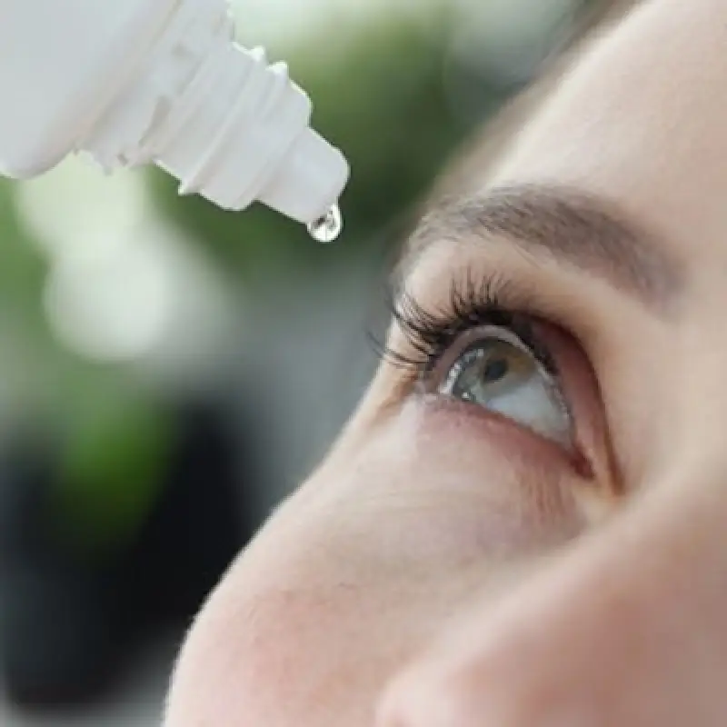 woman dropping eye drops into her eye