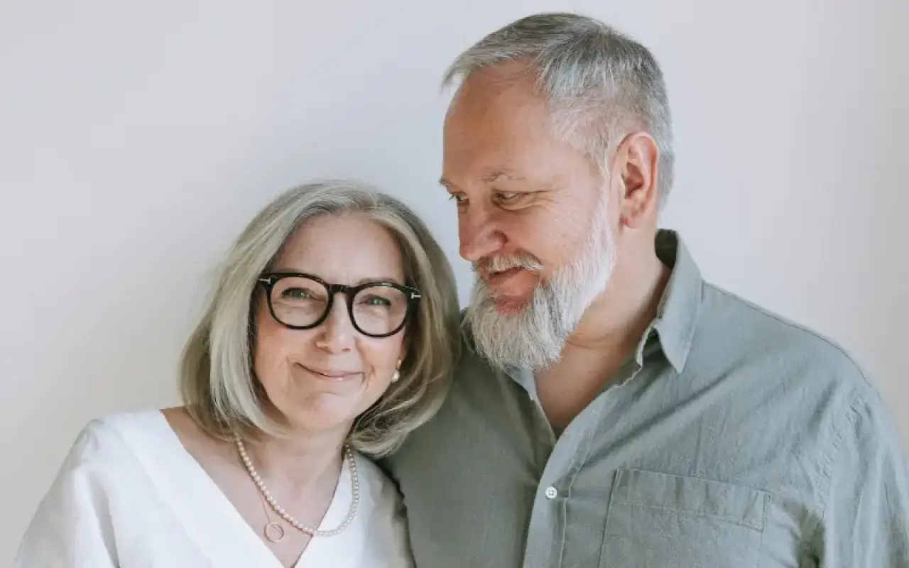 Older man and woman looking at a tablet together while wearing glasses