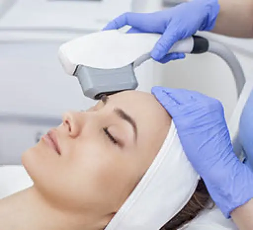 Woman receiving a facial treatment with a handheld device