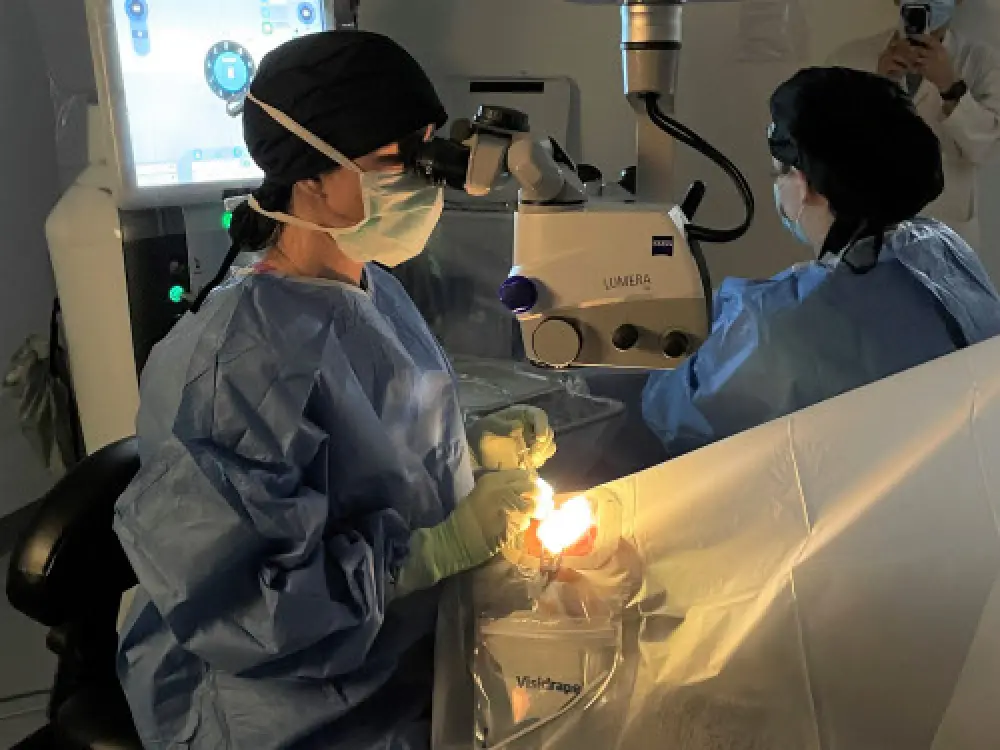 An eye doctor performing a procedure on a person in an exam room.