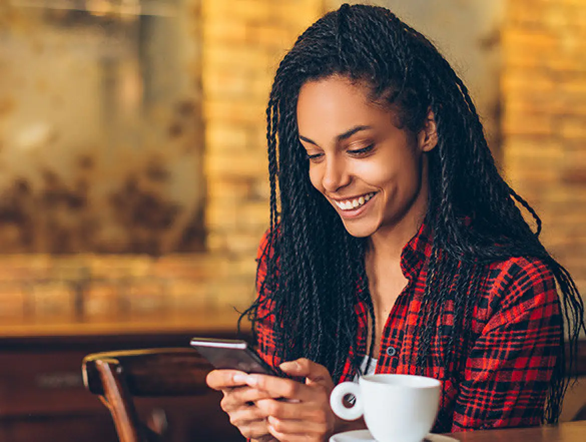 Woman looking at her cellphone and laughing.