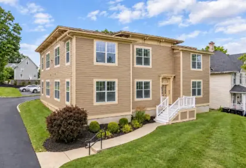 Two-story student apartment building with landscaped lawn in Cortland, New York.
