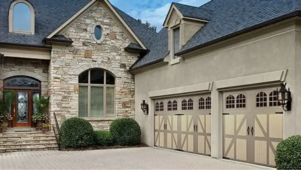 2 story home with european style with tan coloring and rock work