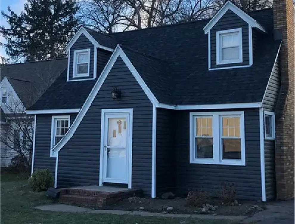 dark blue home with white trim and dark roof