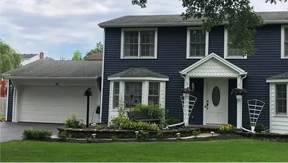 blue home with white trim and gray roof