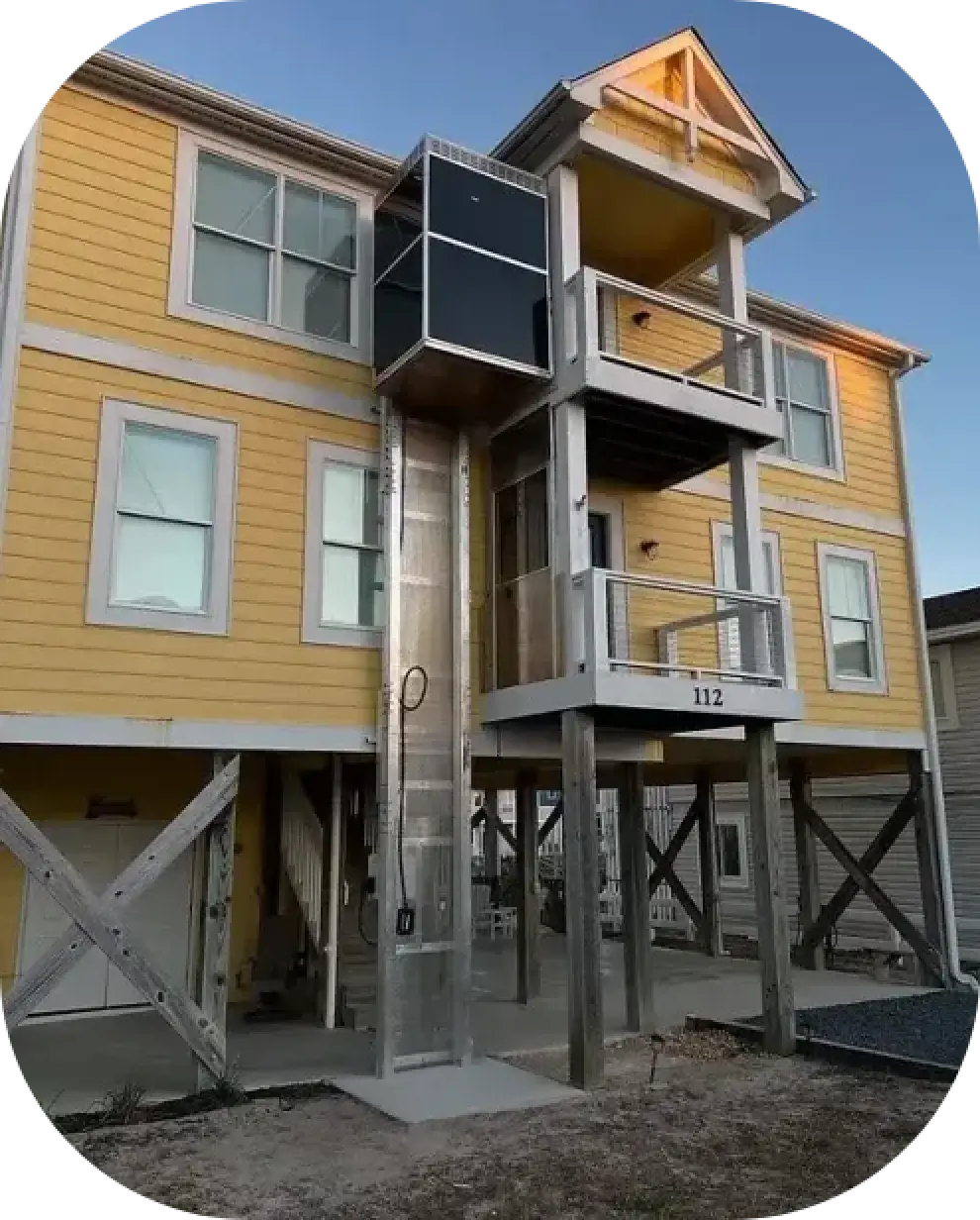 Fully Enclosed Carolina Lift installed on a yellow house