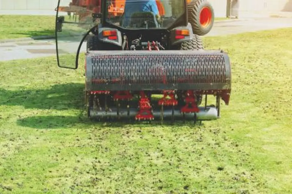 Machine aerating a grassy lawn