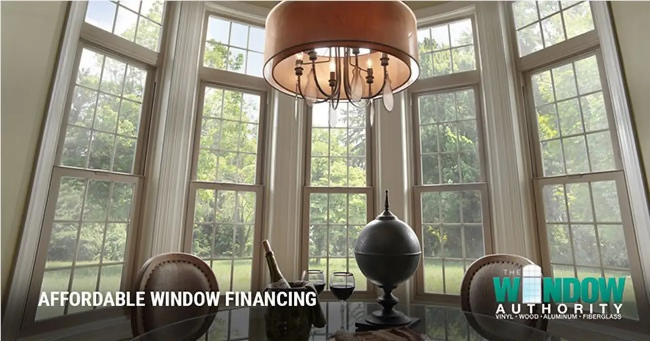 Dining room with tall multi-pane windows overlooking a green yard.