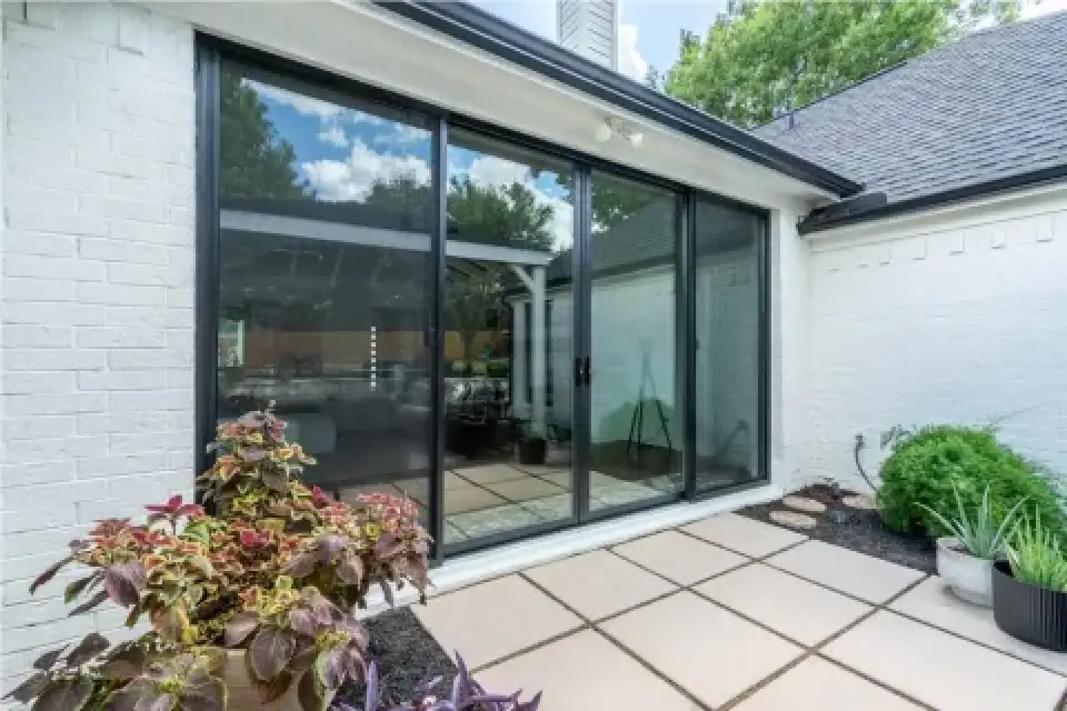 sliding glass doors open onto a patio with potted plants