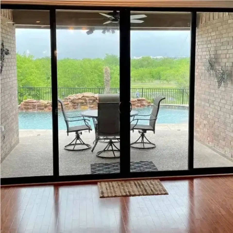 Swimming pool and patio viewed through large sliding glass doors