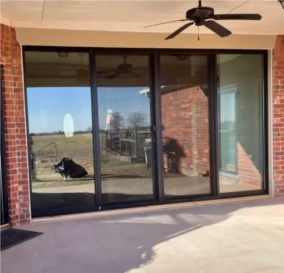 large sliding glass doors reflecting the yard and sky