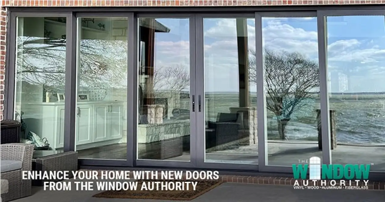 Black-framed glass patio doors overlooking a waterfront from a brick home.