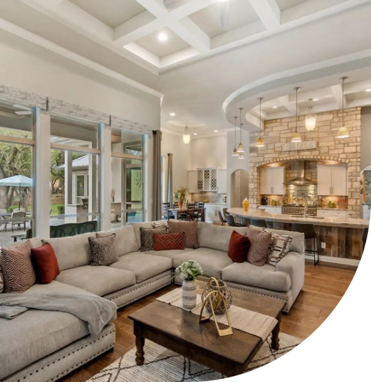 modern open-concept living room and kitchen with a large gray sectional sofa and pendant lights