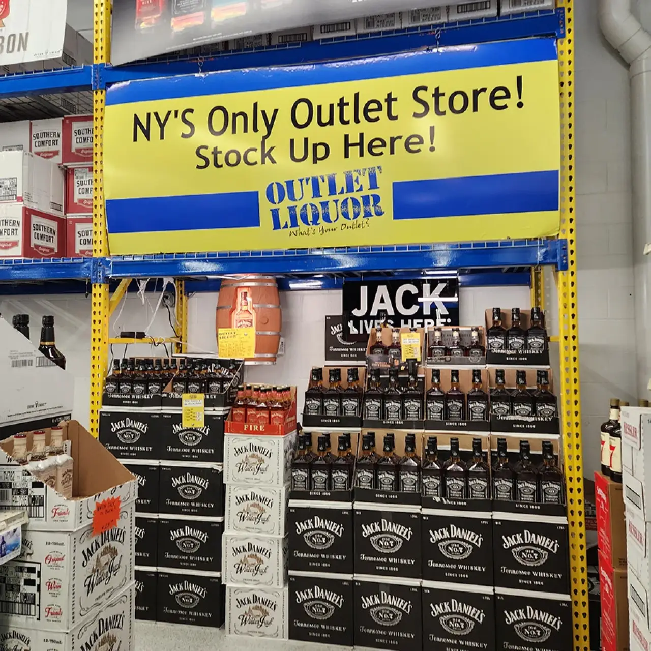 jack daniels bottle display under a yellow and blue new yorks only outlet store sign