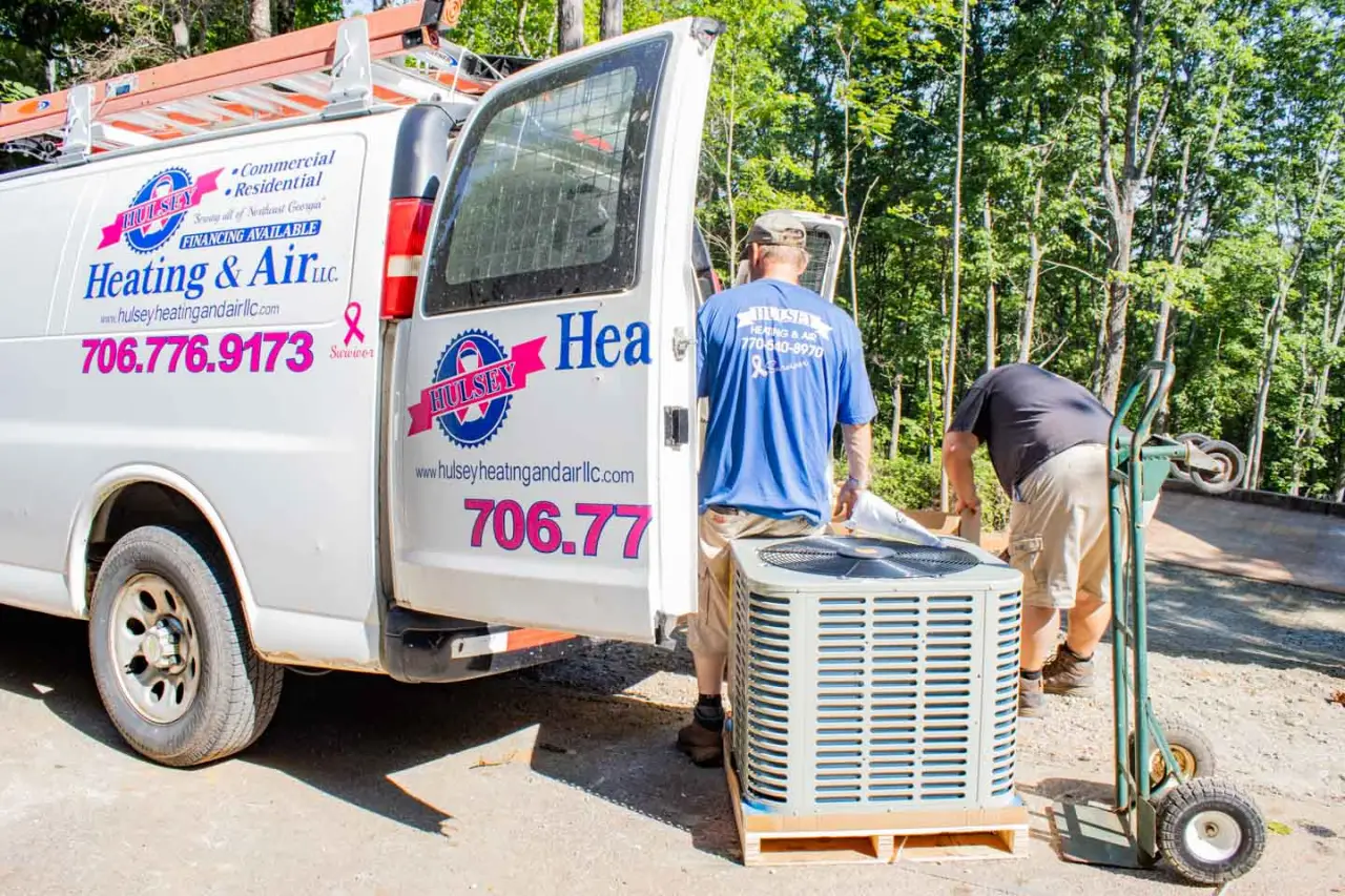 Hulsey employees loading an old AC unit