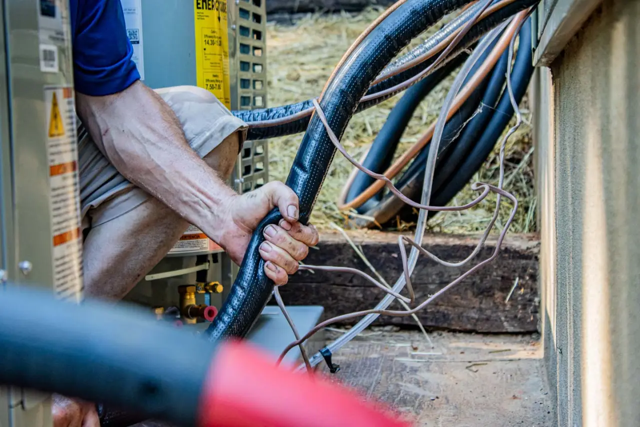 Husley Employee arm gripping an AC connector pipe