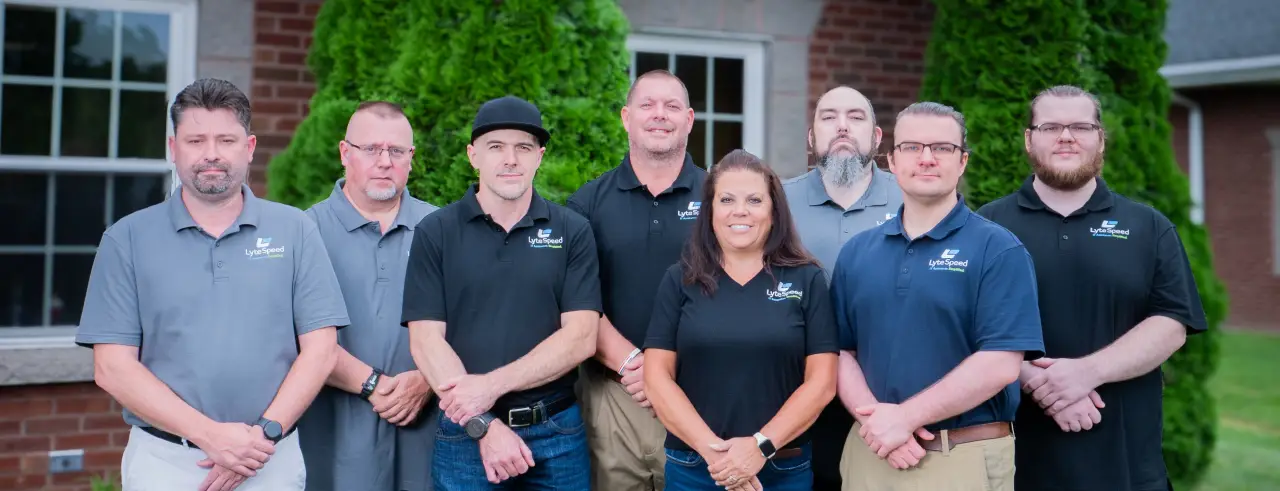The LyteSpeed team of eight standing together on the lawn outside their office