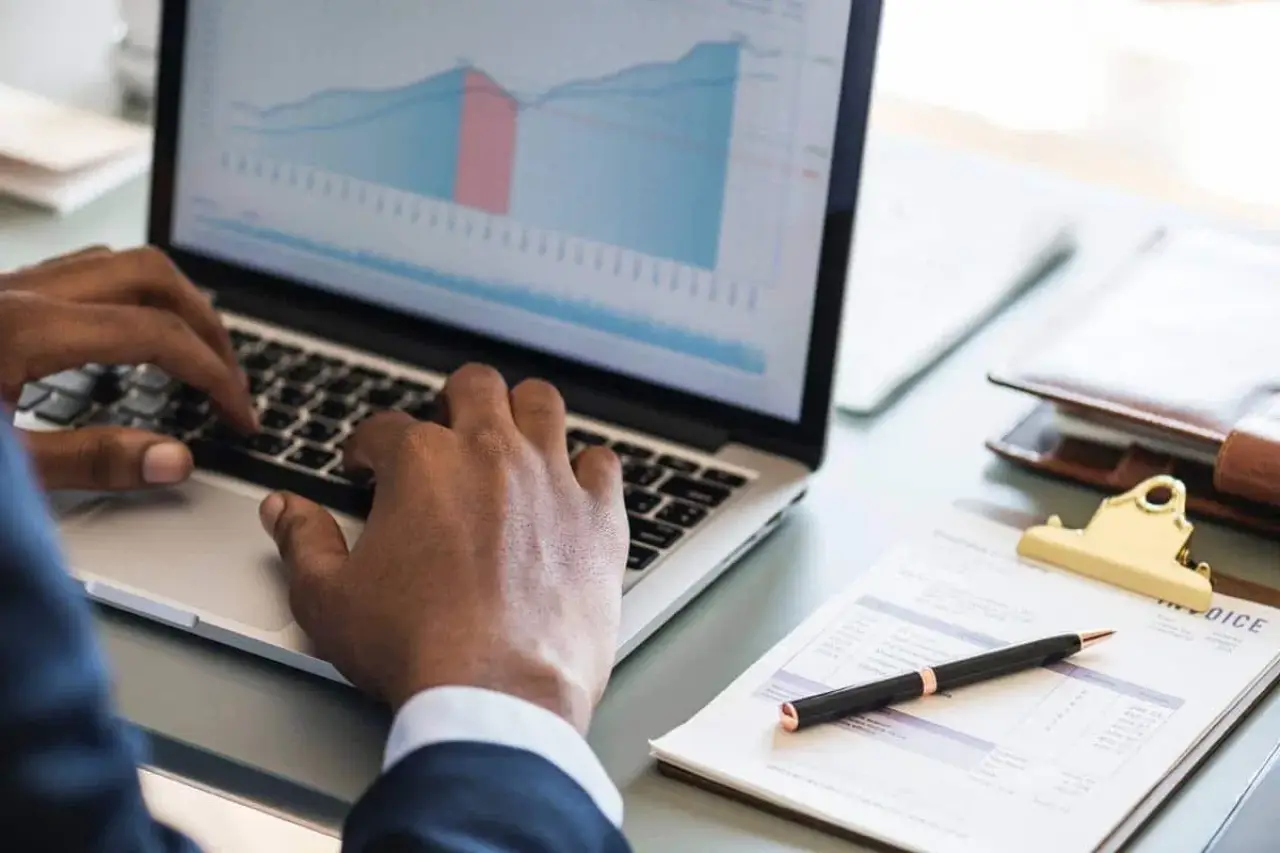 Business professional reviewing technology and financial performance data on a laptop