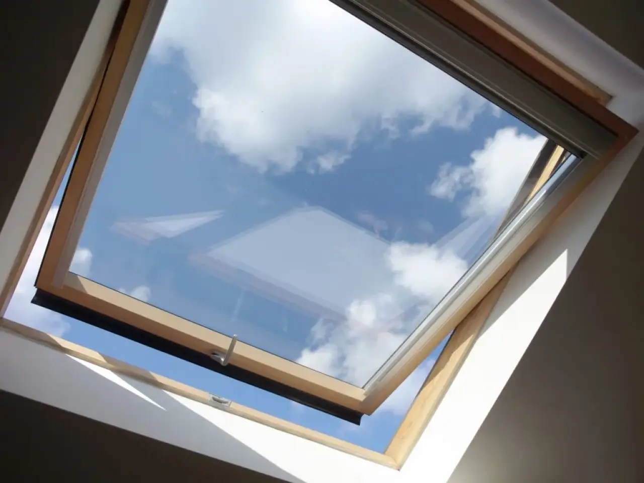 Open skylight revealing blue sky and white clouds.