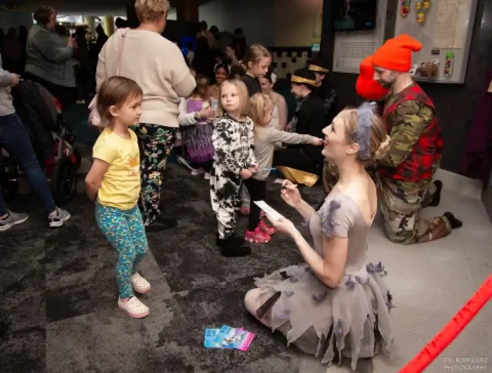 Ballet dancer greets children backstage at The Ugly Duckling.