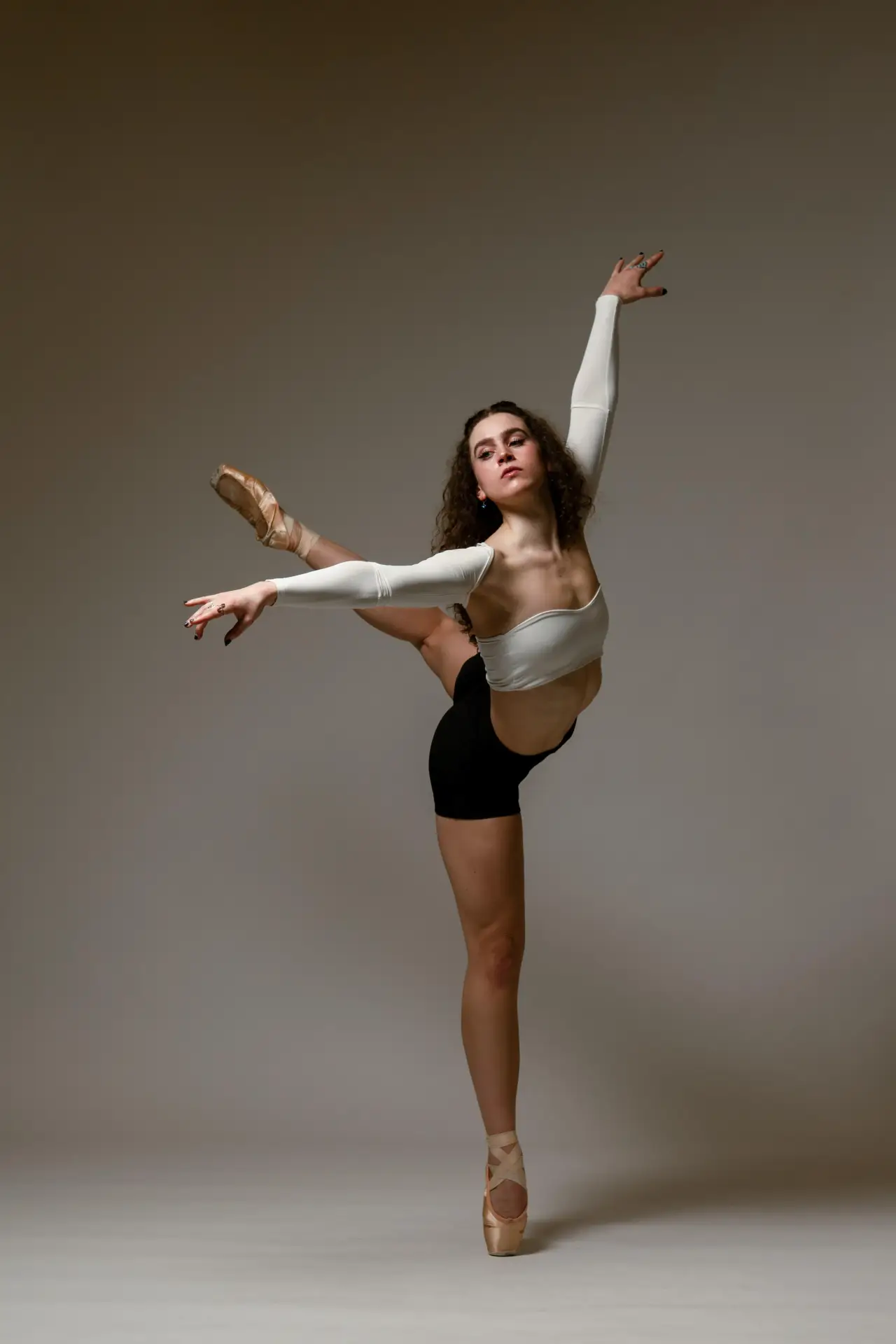 Adult ballet dancer in an arabesque in the studio