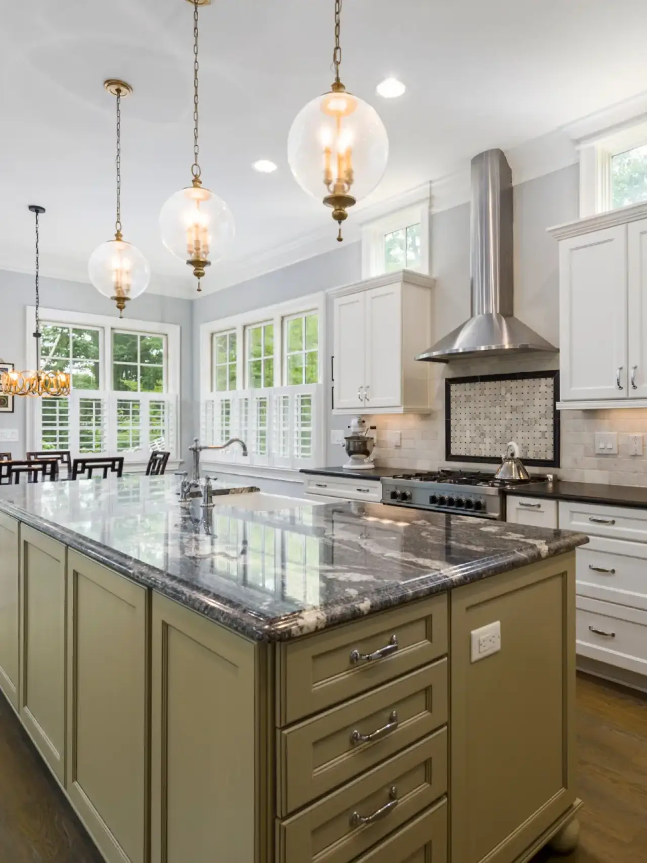 Spacious modern kitchen with a large island, pendant lights, and white cabinets.