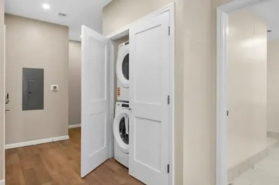 Hallway with in-unit stacked washer and dryer closet.