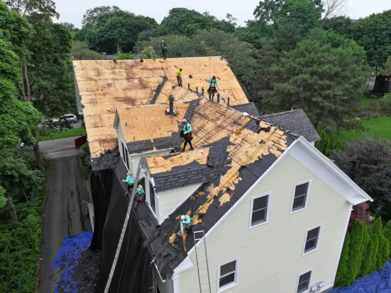 Roofing crew removes old shingles from a large Rochester home.