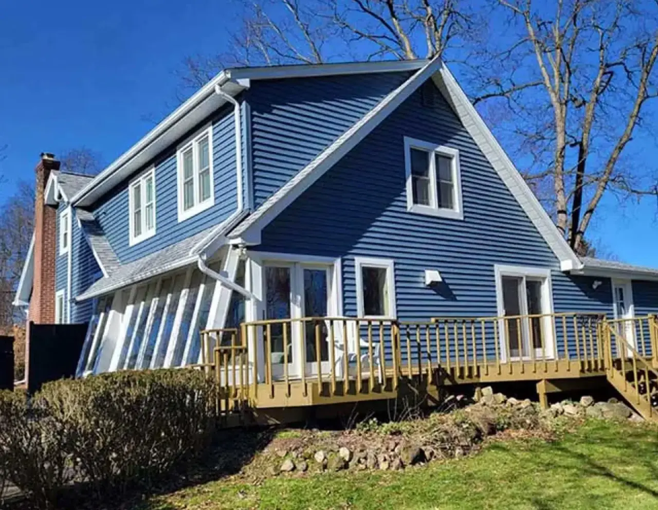 Blue home exterior with white trim and a raised deck.