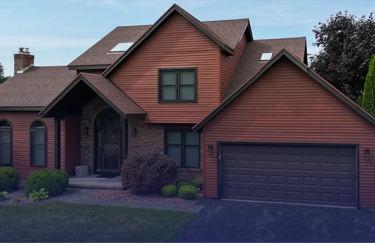 Two-story home with red siding and dark trim.