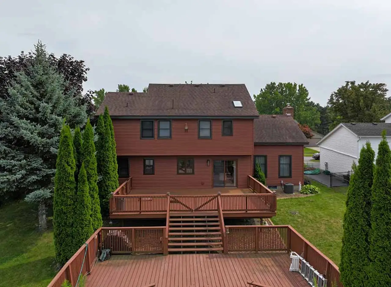 A red house with a large wooden porch.