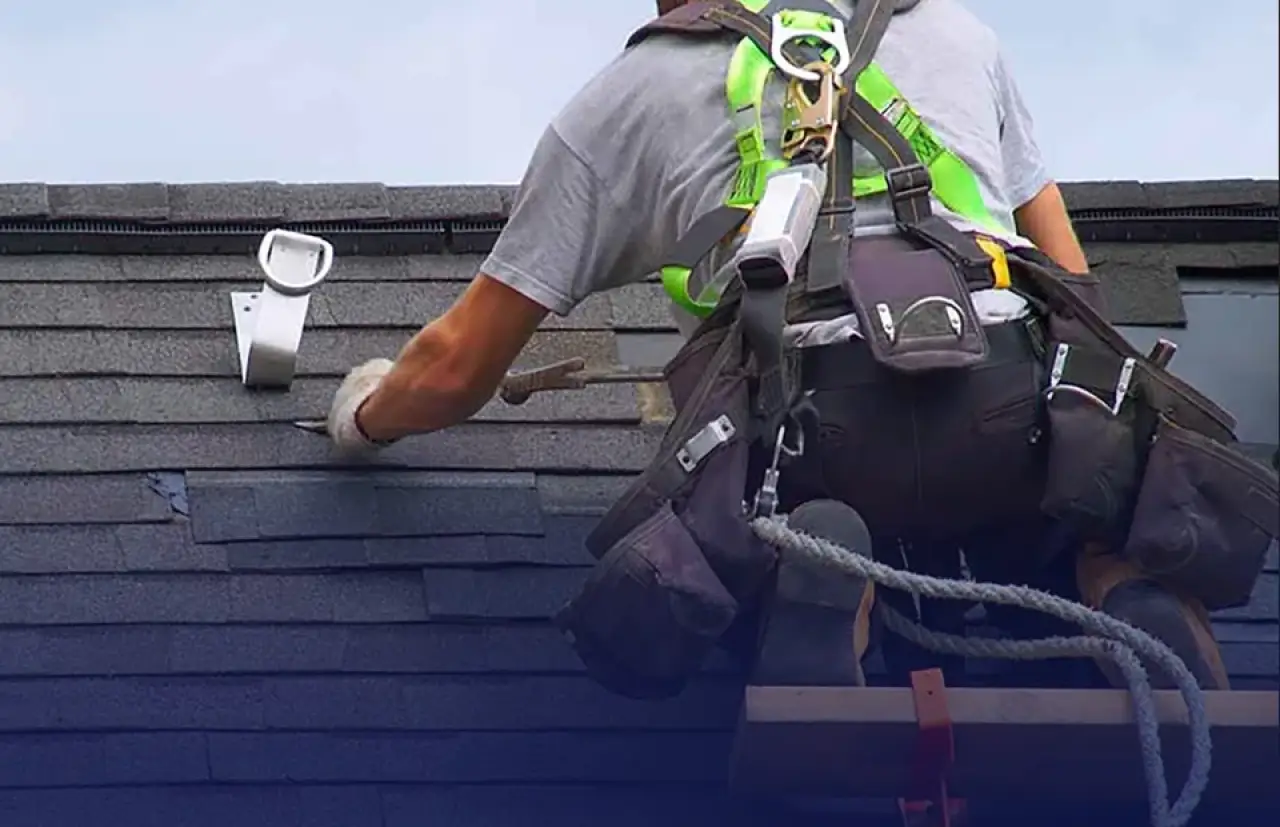 A construction worker laying a new roof.