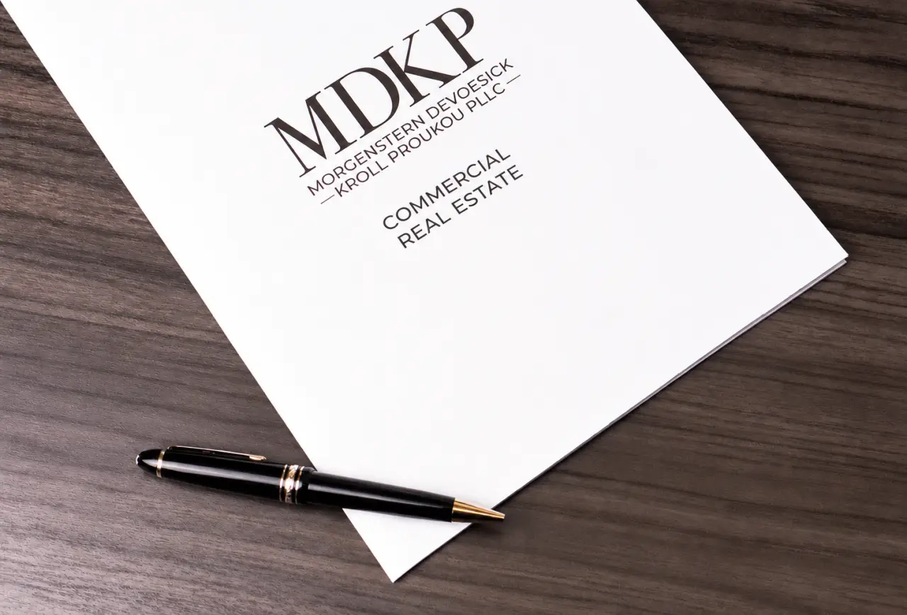 MDKP Commercial Real Estate document resting on a desk with a pen