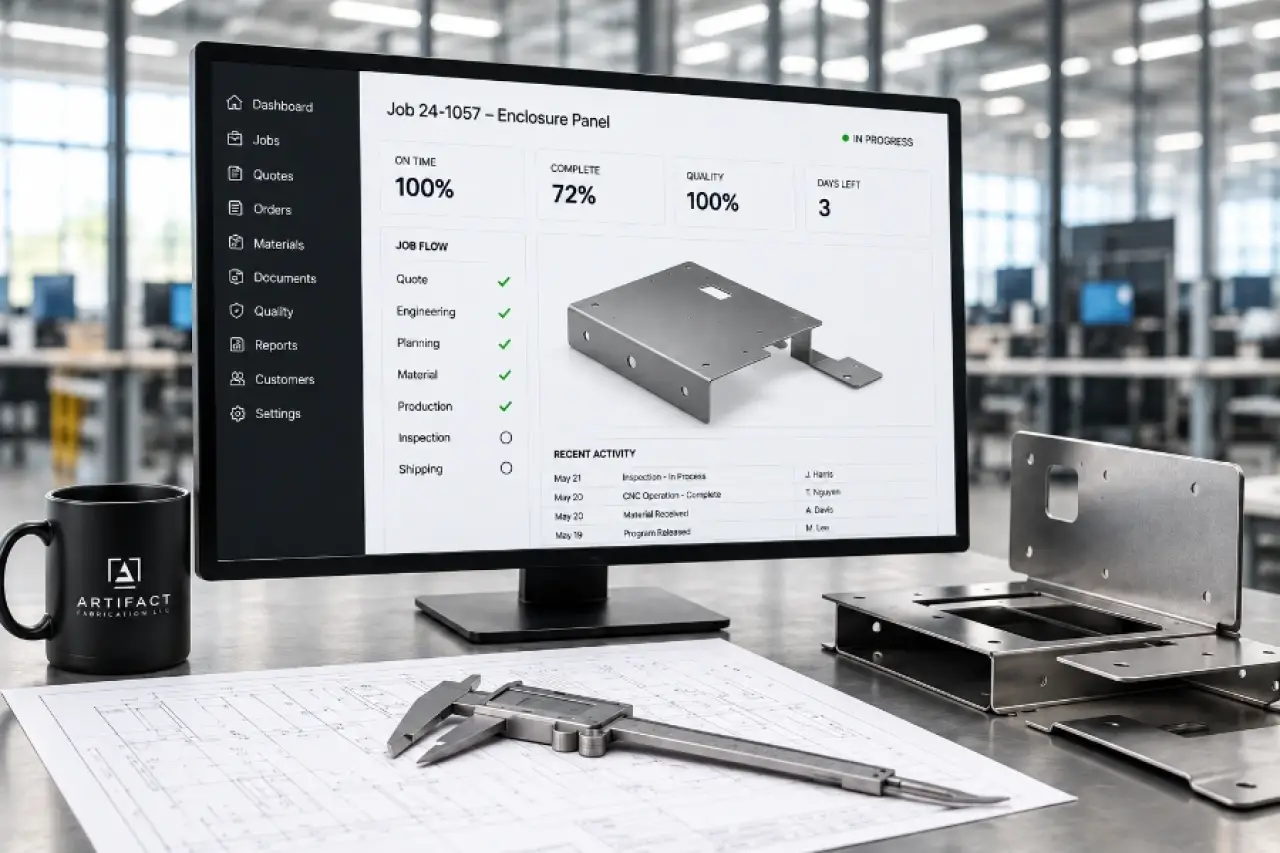 Job tracking dashboard on a monitor beside a fabricated enclosure panel and calipers