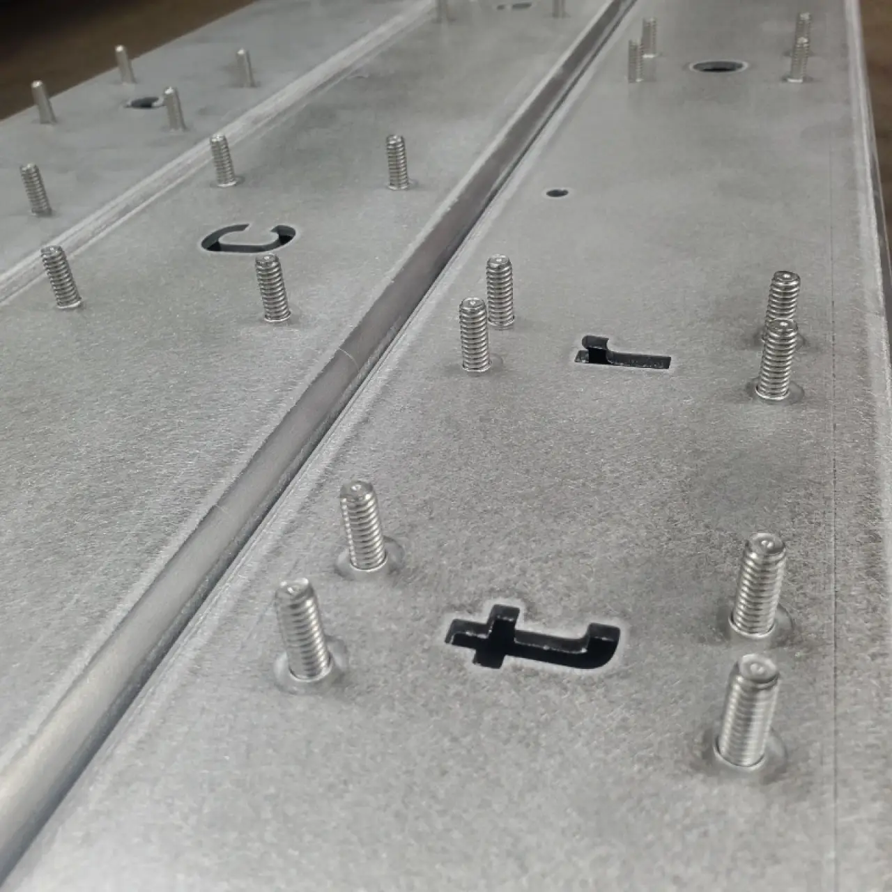 Rows of auto-fed studs installed across a sheet metal panel