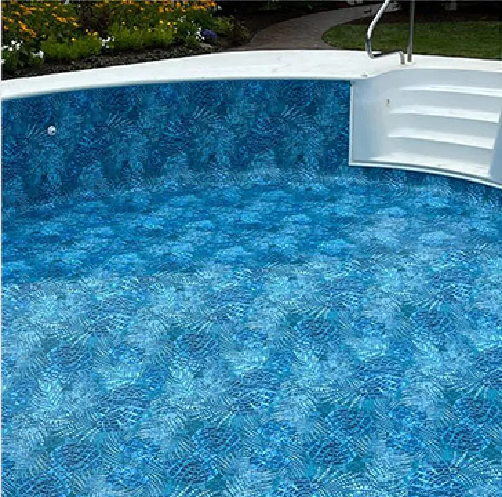 An empty swimming pool with a blue patterned liner and white steps leading into it.