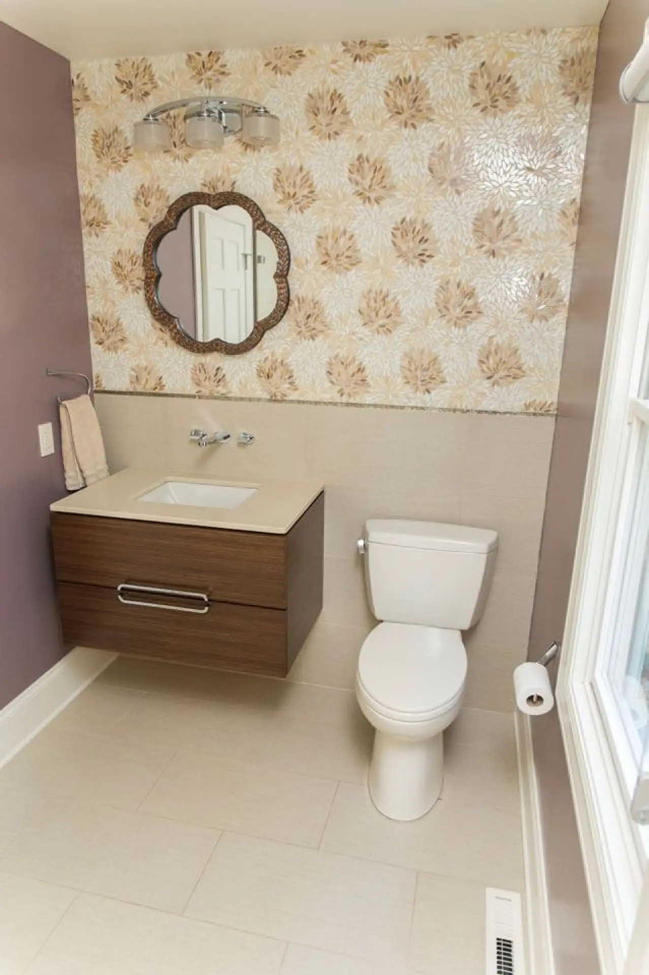 vanity bathroom design with mosaic tile, a floating vanity and italian faucet