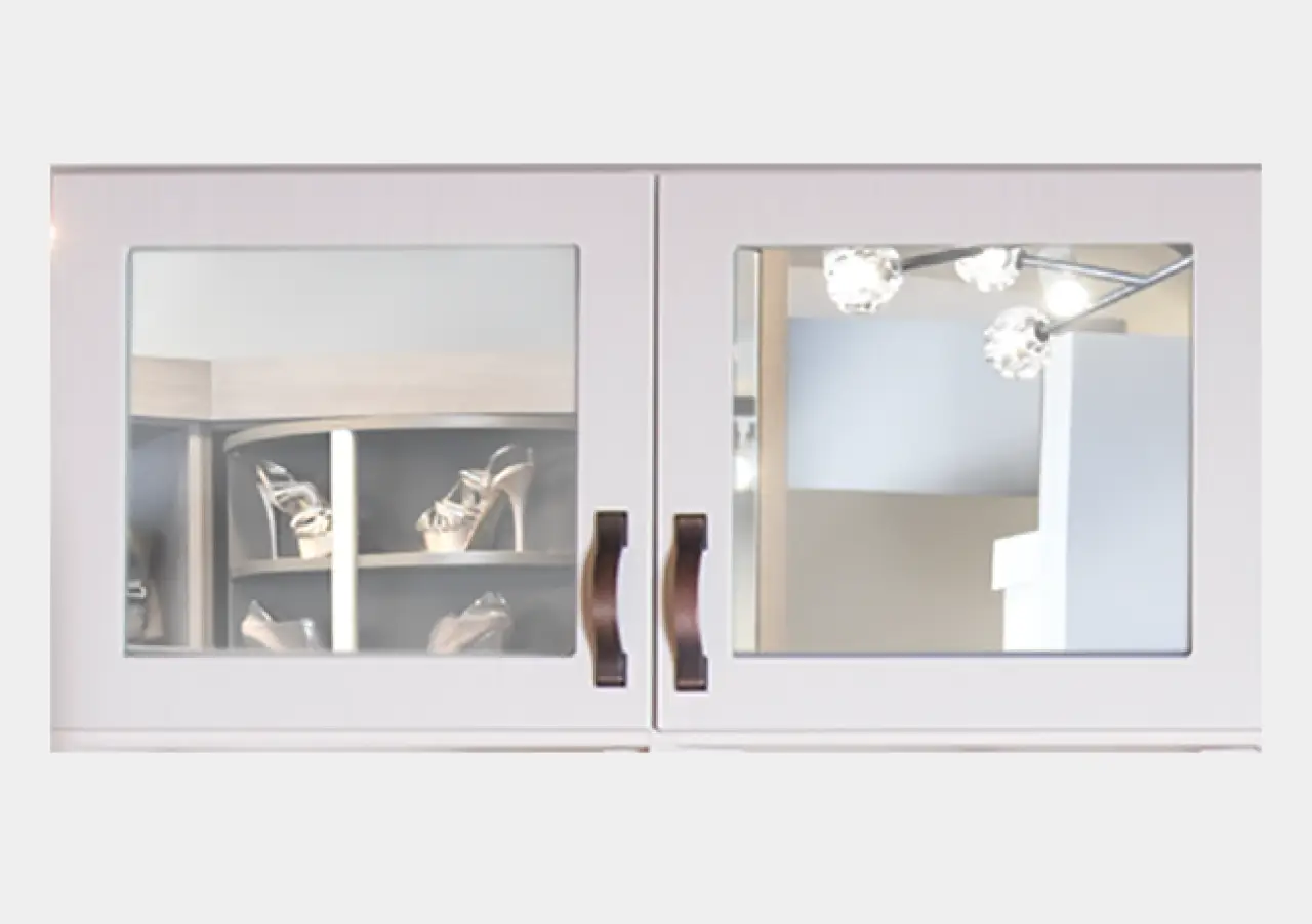 White cabinet with glass doors, reflecting shelves with high-heeled shoes and ceiling lights.