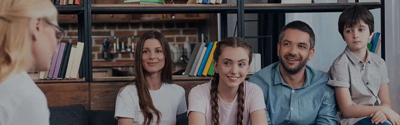 family sitting together smiling at counseling