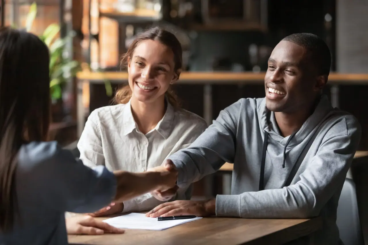 A man and woman in aprons looking at a laptop screen together.