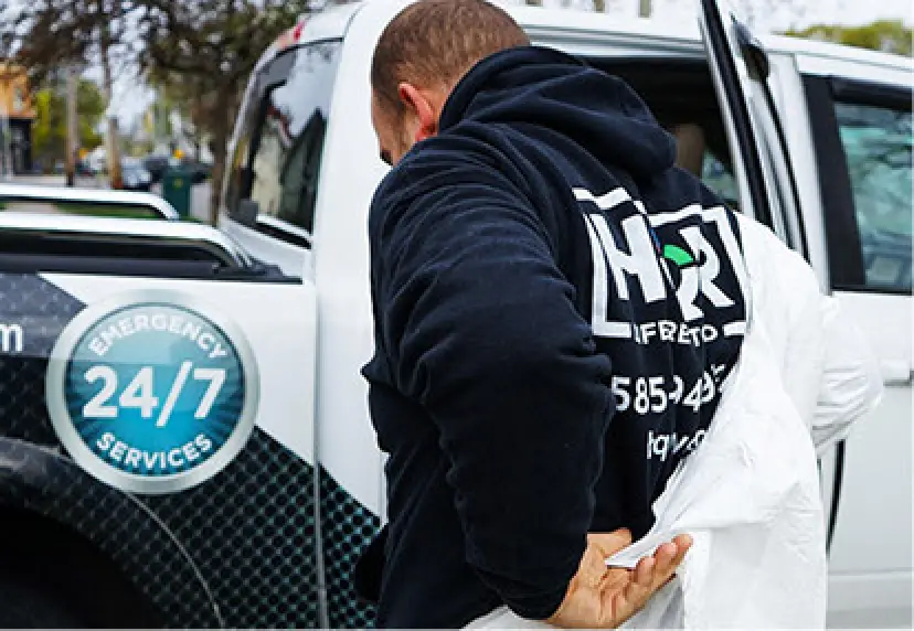 Man in hoodie getting into a truck with 24/7 Emergency Services written on the side.