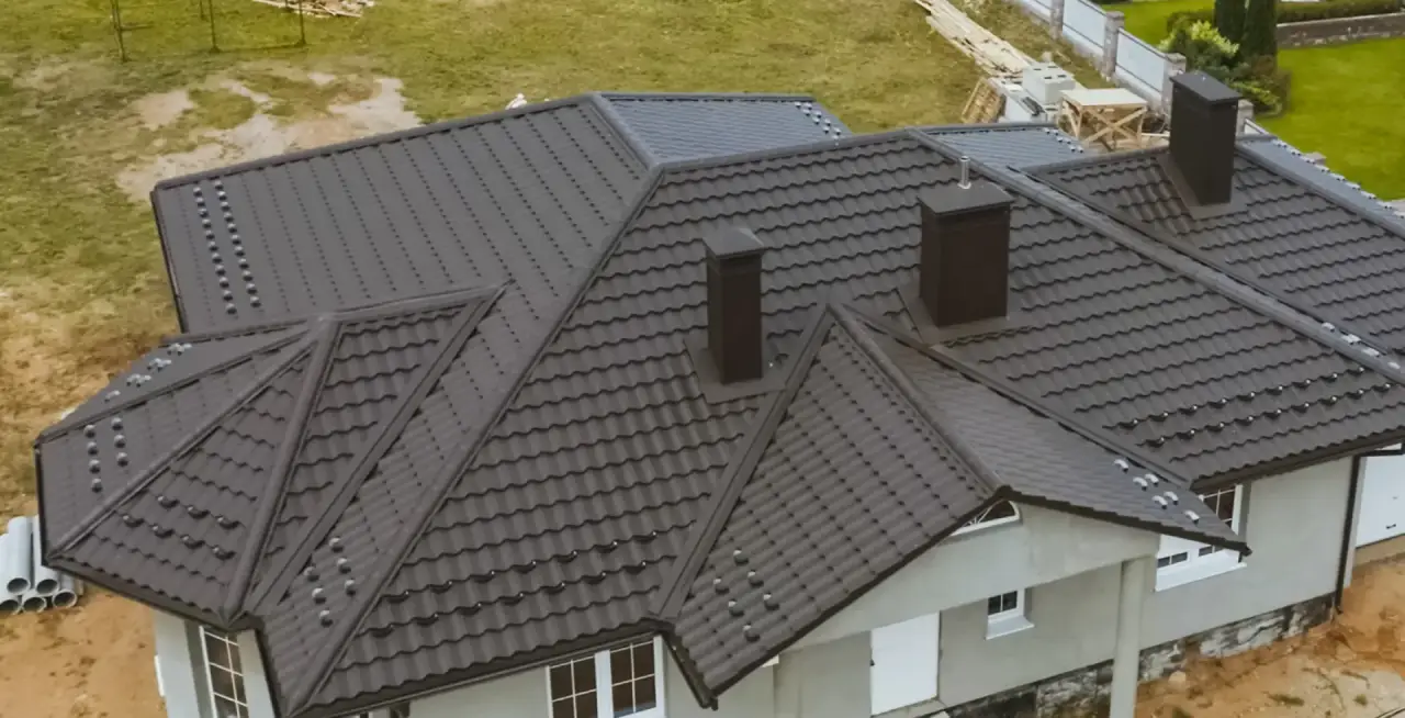 Newly installed dark metal roof on a home under construction.