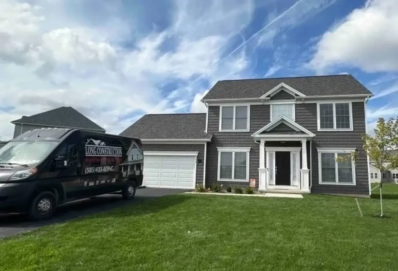 Long Construction van parked outside a gray two-story Rochester home.