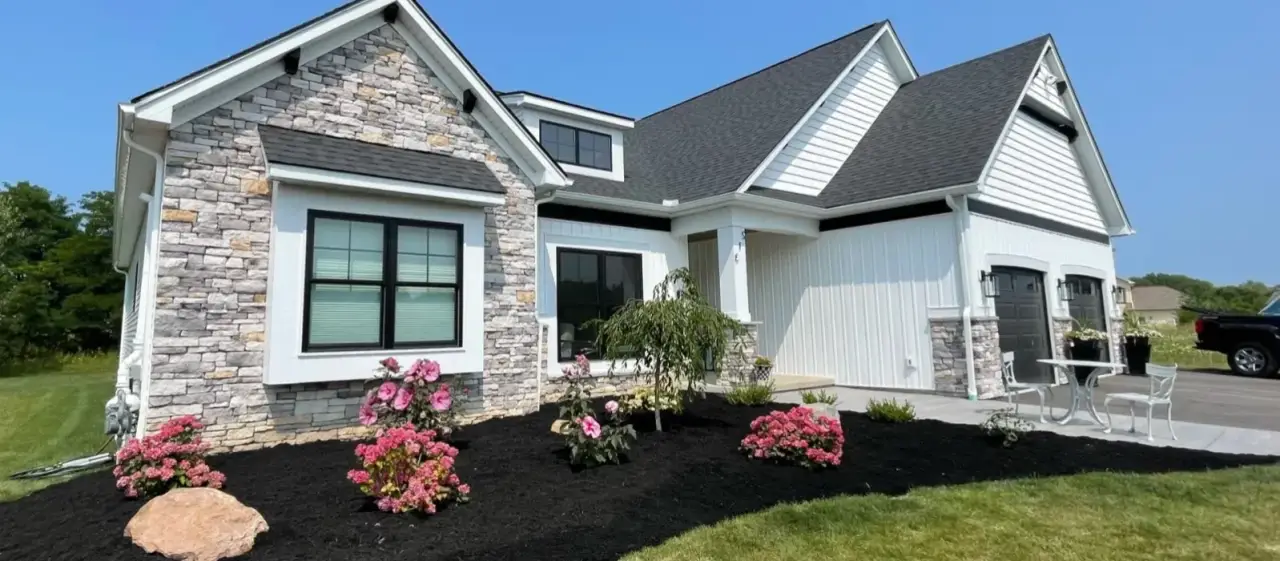 fresh mulch and flower bushes in front of brick home