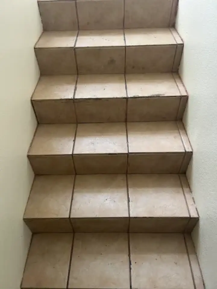 Beige tiled staircase before a detailed cleaning.