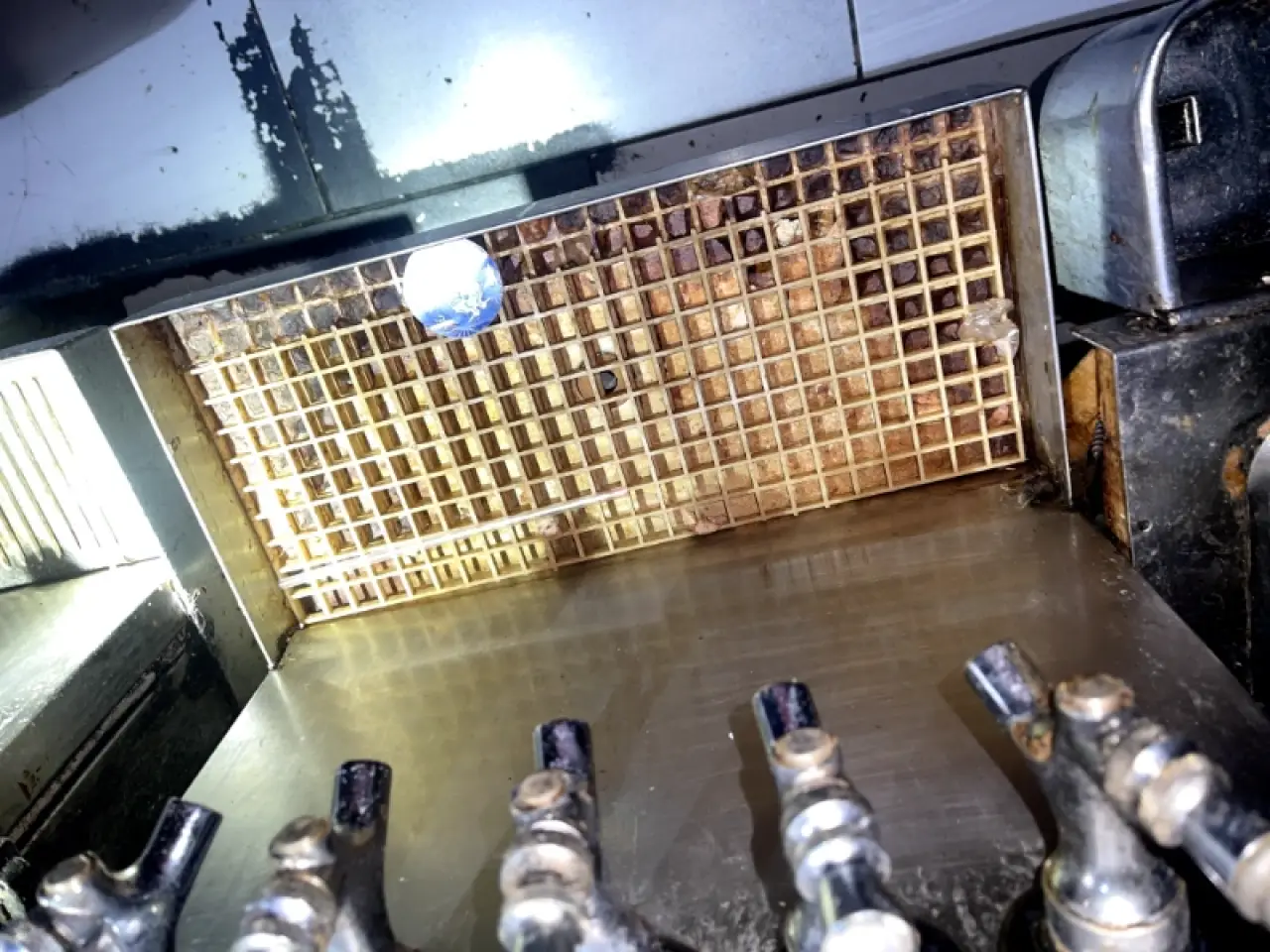 Grease buildup on a commercial stovetop and tiled backsplash.