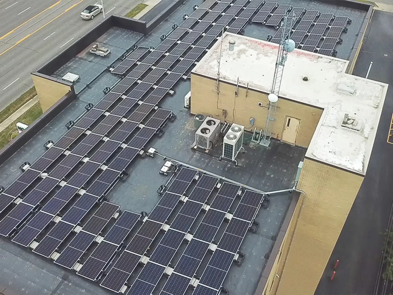 Commercial rooftop covered with rows of solar panels.